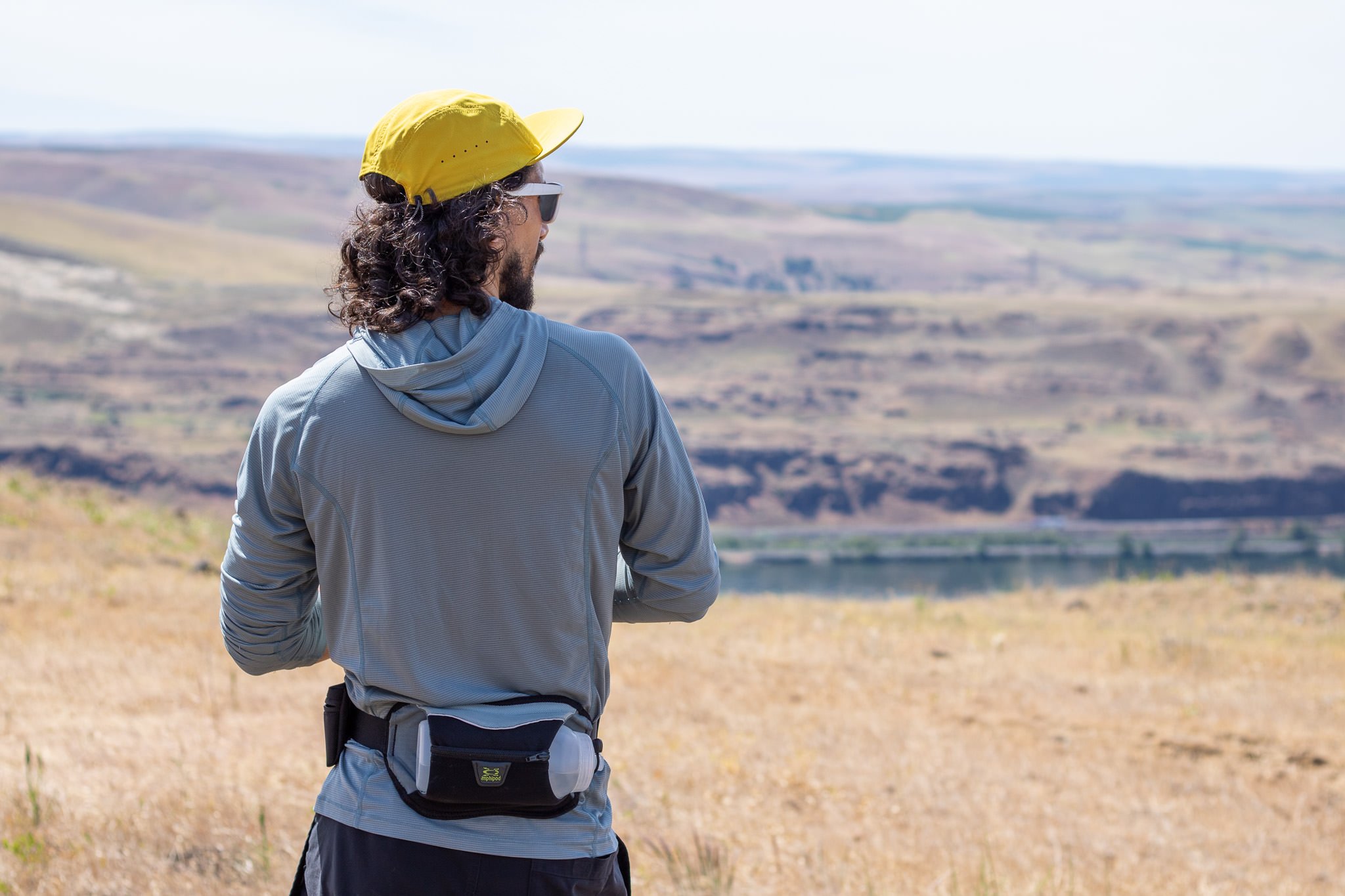 A runner wearing the Outdoor Research Echo Hoodie looking out over distant hills