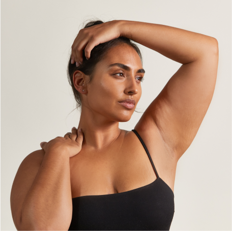 woman with sun glistening on face and hand touching her hair