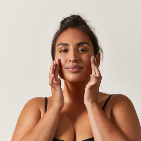 woman with sun glistening on face and hand touching her hair
